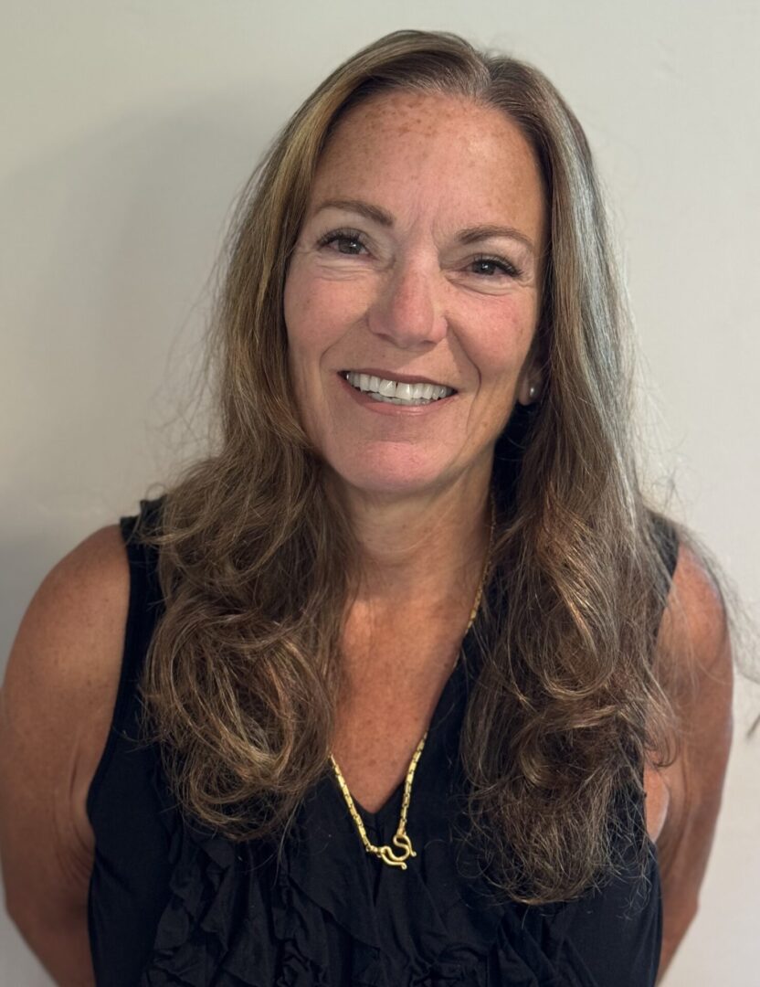 A woman with long hair and a smile.